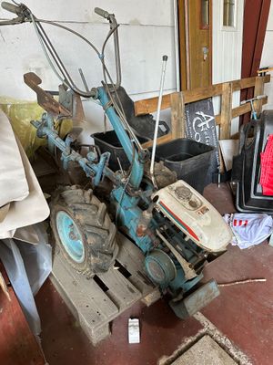 a small blue tractor sitting next to a television