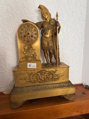 a gold statue of a man holding a shield and a shield