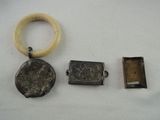 two pieces of silver and a ring on a white surface