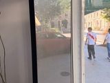 two people walking down the sidewalk through a glass door