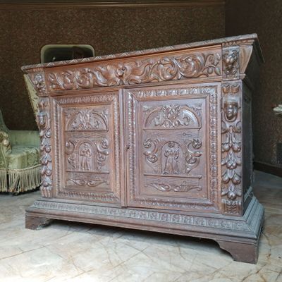 un grand coffre en bois orné de sculptures, dans une pièce