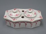 une image représentant une boîte blanche et rouge avec un couvercle, posée sur une table