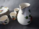 a pitcher and cups sitting next to each other on a table