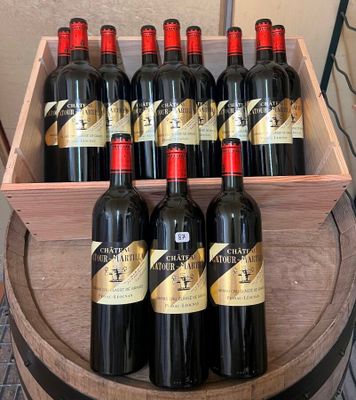 plusieurs bouteilles de vin rouge dans une caisse en bois posée sur un tonneau