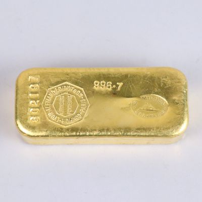 a close up of a gold bar on a white surface