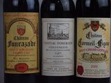 three bottles of red wine are lined up on a table