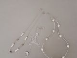 Des colliers, des bracelets et des boucles d'oreilles sont disposés sur une table