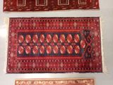 three oriental rugs on display on a table in a room