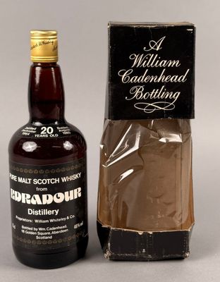 une image d'une bouteille de whisky à côté d'une boîte en carton