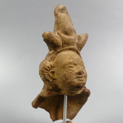 une statue représentant un oiseau posé sur un bâton fixé à un poteau