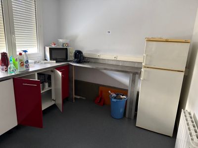 a small kitchen with a refrigerator and a microwave in it
