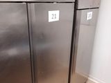 two stainless steel refrigerators in a kitchen with tile flooring