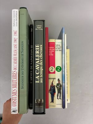 a person holding a stack of books in their hand