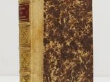 an old book sitting on top of a white table