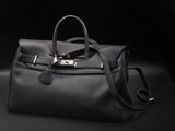 a black leather handbag on a black background