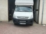 une camionnette blanche garée devant un garage