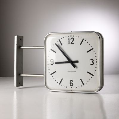 une horloge posée sur une table devant un mur