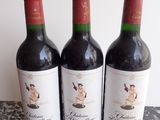 three bottles of wine sitting on top of a table next to each other