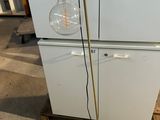 a white refrigerator with a light bulb on top of it