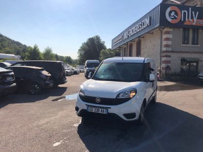 the small white van is parked in front of a building