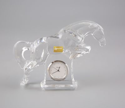 une figurine en verre représentant un cheval, sur laquelle est placée une horloge