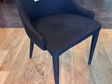 une chaise noire avec une étiquette de prix dans un magasin