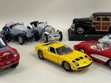 several toy cars are lined up in a row on a white surface