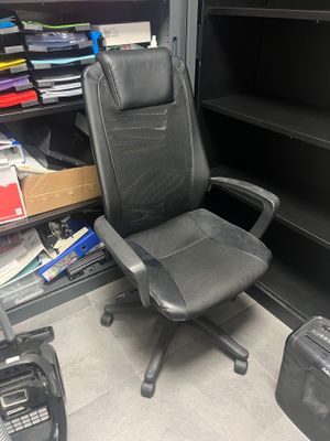 une chaise de bureau noire placée devant une bibliothèque