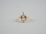 Gros plan sur une bague en or ornée d'une topaze bleue