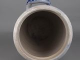 a blue and white vase sitting on a gray surface