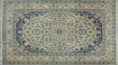 un tapis persan ancien, avec une bordure bleue et un motif floral