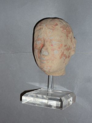 a clay head of a man on a clear stand