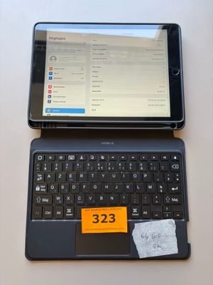 a tablet computer sitting on top of a laptop keyboard