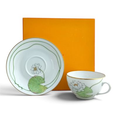 a cup and saucer sitting next to an orange box