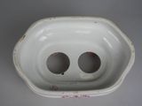 a white porcelain bowl with two holes in it