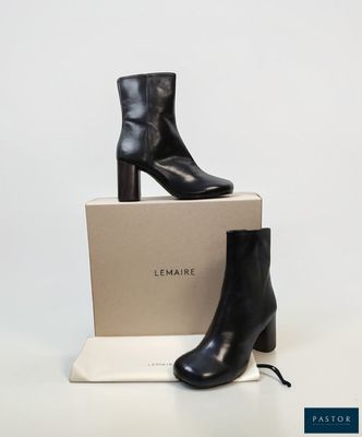 a pair of black leather ankle boots sitting on top of a box