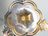 a silver vase with a flower on top of it