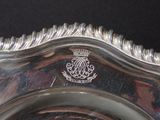 a silver plate with a crown on it on a table