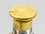 a glass bottle with a gold cap on top of it