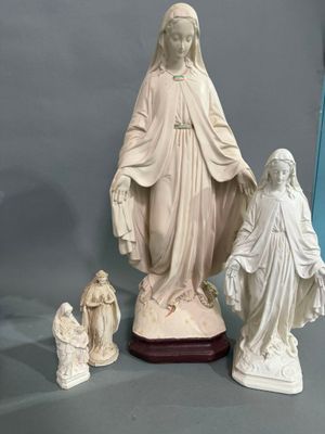 une statue représentant une femme tenant l'enfant Jésus dans ses bras, ainsi que trois autres figurines