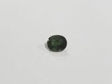 a green tourmaline gems on a white surface