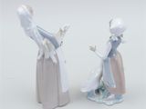two figurines of a woman and a man standing next to each other