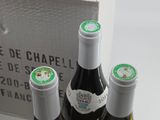 three bottles of wine sitting in a box on a table