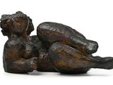 une statue représentant une femme allongée sur une surface blanche
