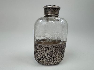 an antique silver plated glass bottle with a silver lid