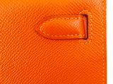 a close up of an orange leather wallet with a metal clasp