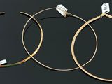 deux paires de boucles d'oreilles créoles en or sur fond noir