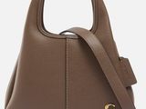 a brown leather handbag with a gold logo on the front