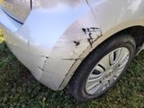 a white car that has been damaged and is sitting in the grass