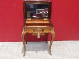 a small wooden desk with a mirror on top of it